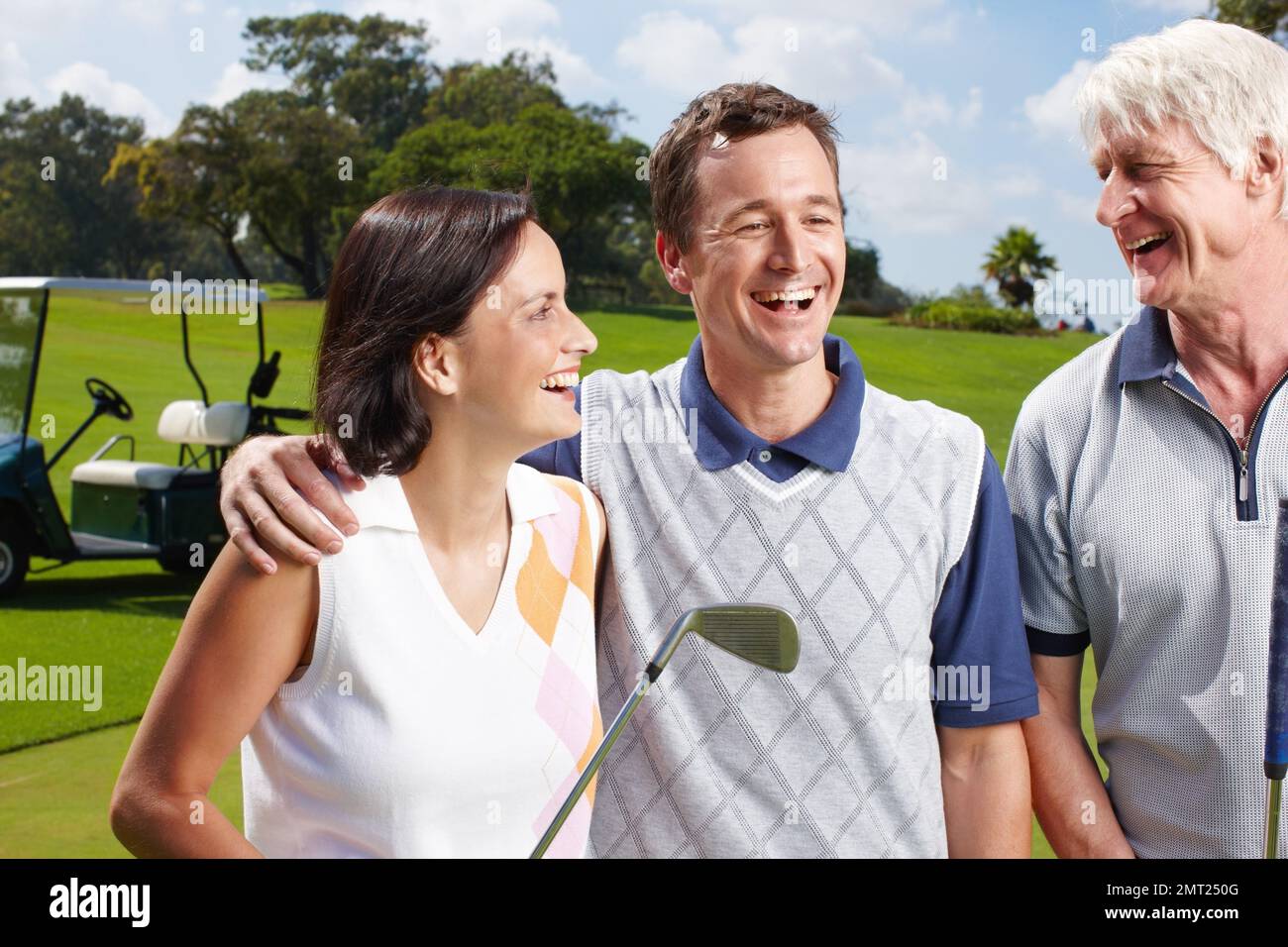 Enjoying a days golf together. Smiling golfing companions on the green with their golf cart in the background. Stock Photo