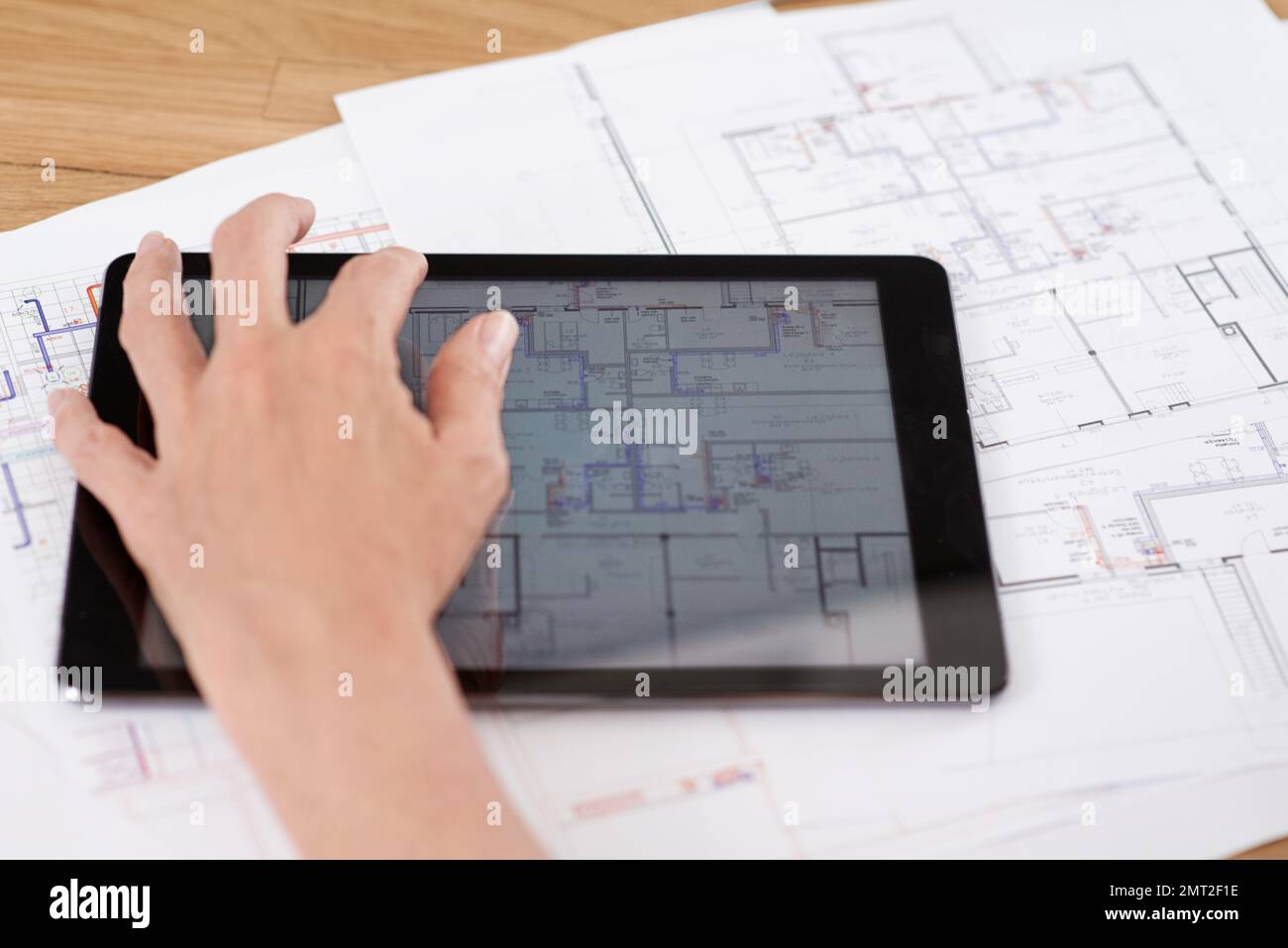Architecture meets technology. Cropped image of an architect working on building plans on her digital tablet. Stock Photo