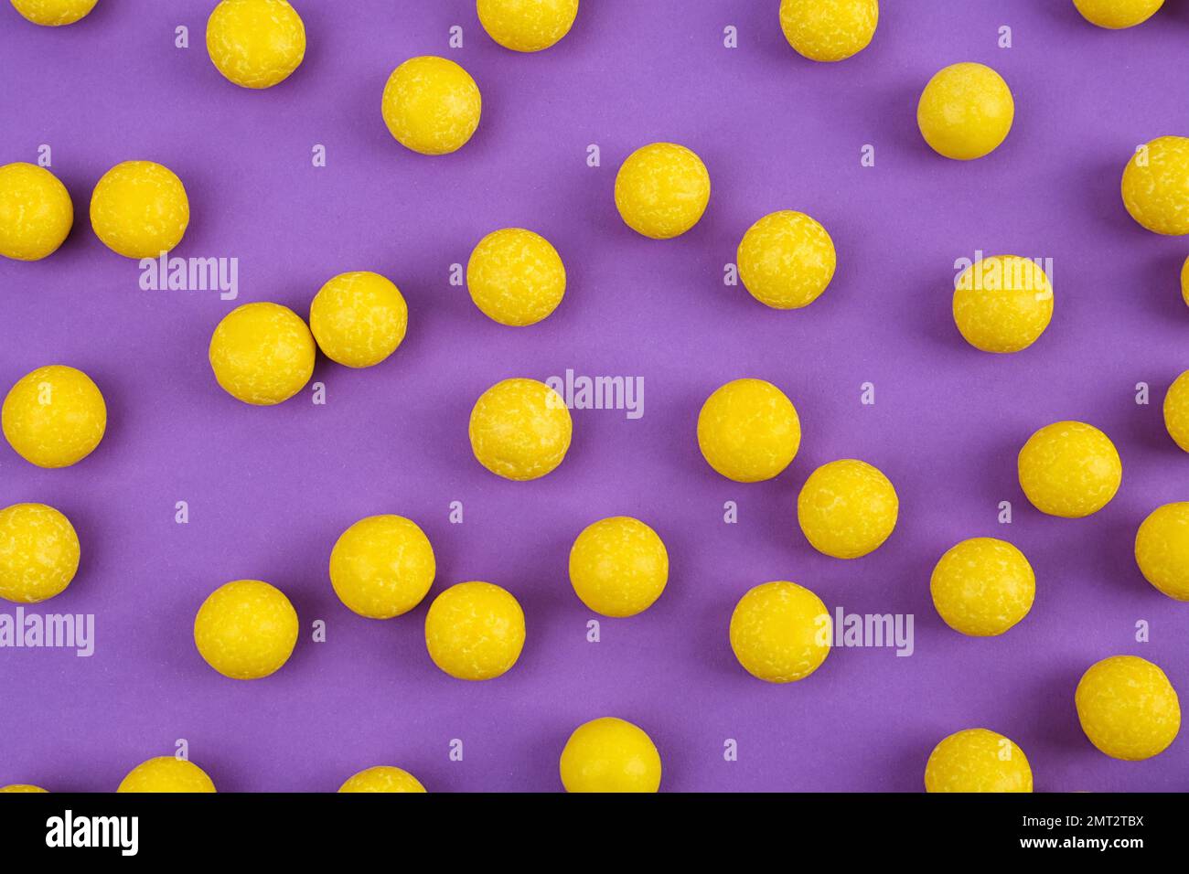 Delicious lemon chewing gums on purple background, flat lay Stock Photo