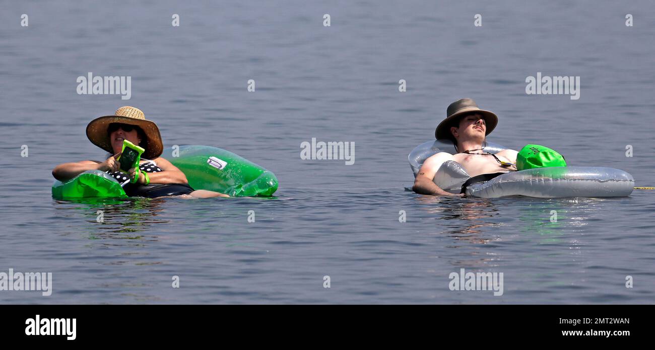 People float on inflatable beach toys in Lake Washington, Thursday, Aug. 3,  2017, in Seattle. An excessive heat warning for the area continues through  Friday evening, as unusually hot weather will bring