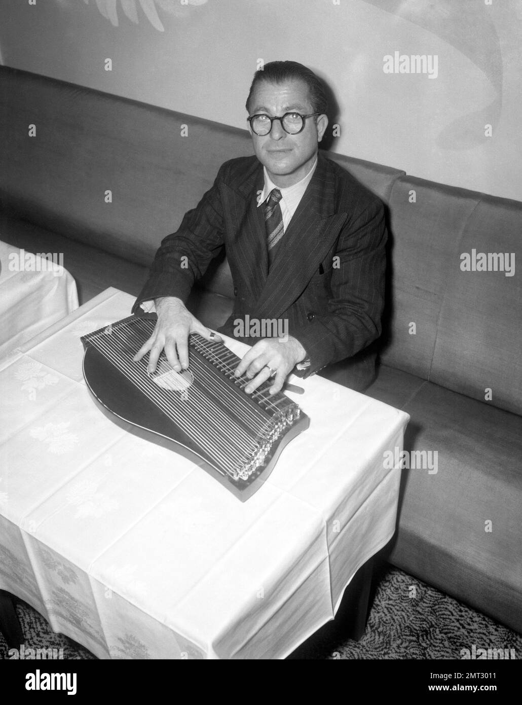 Shortly after his arrival in London, Anton Karas plays at an Empress Club press reception on Nov. 14, 1949. (AP Photo/Dennis-Lee Royle) Stock Photo