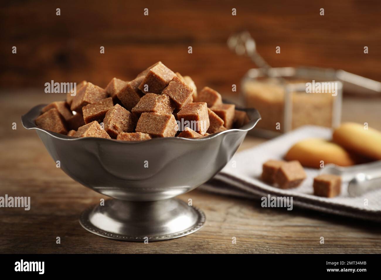 https://c8.alamy.com/comp/2MT34MB/brown-sugar-cubes-in-metal-bowl-on-wooden-table-2MT34MB.jpg