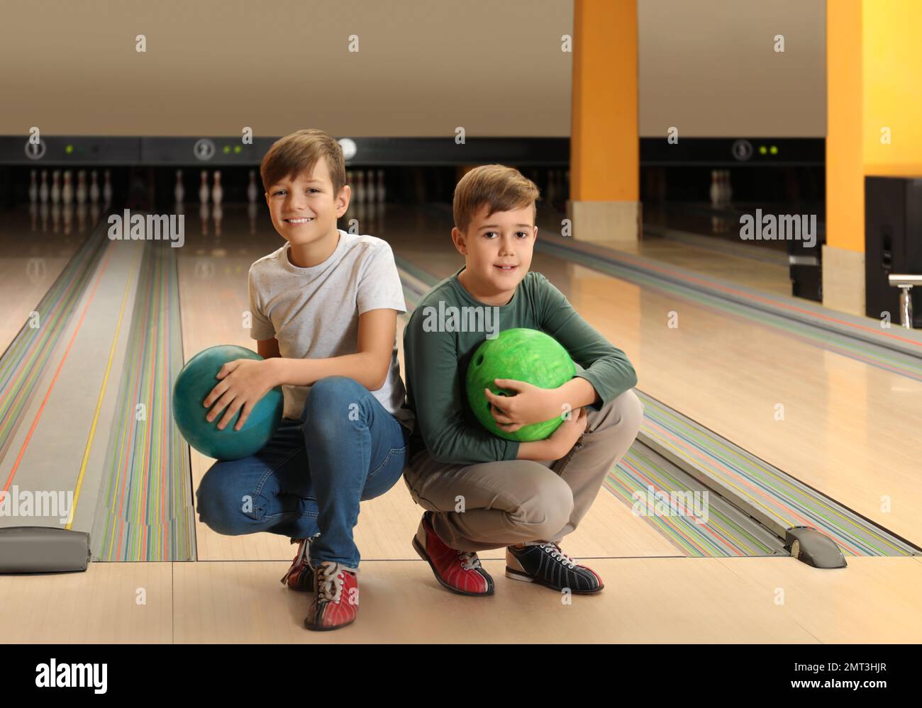 Happy boys with balls in bowling club Stock Photo - Alamy