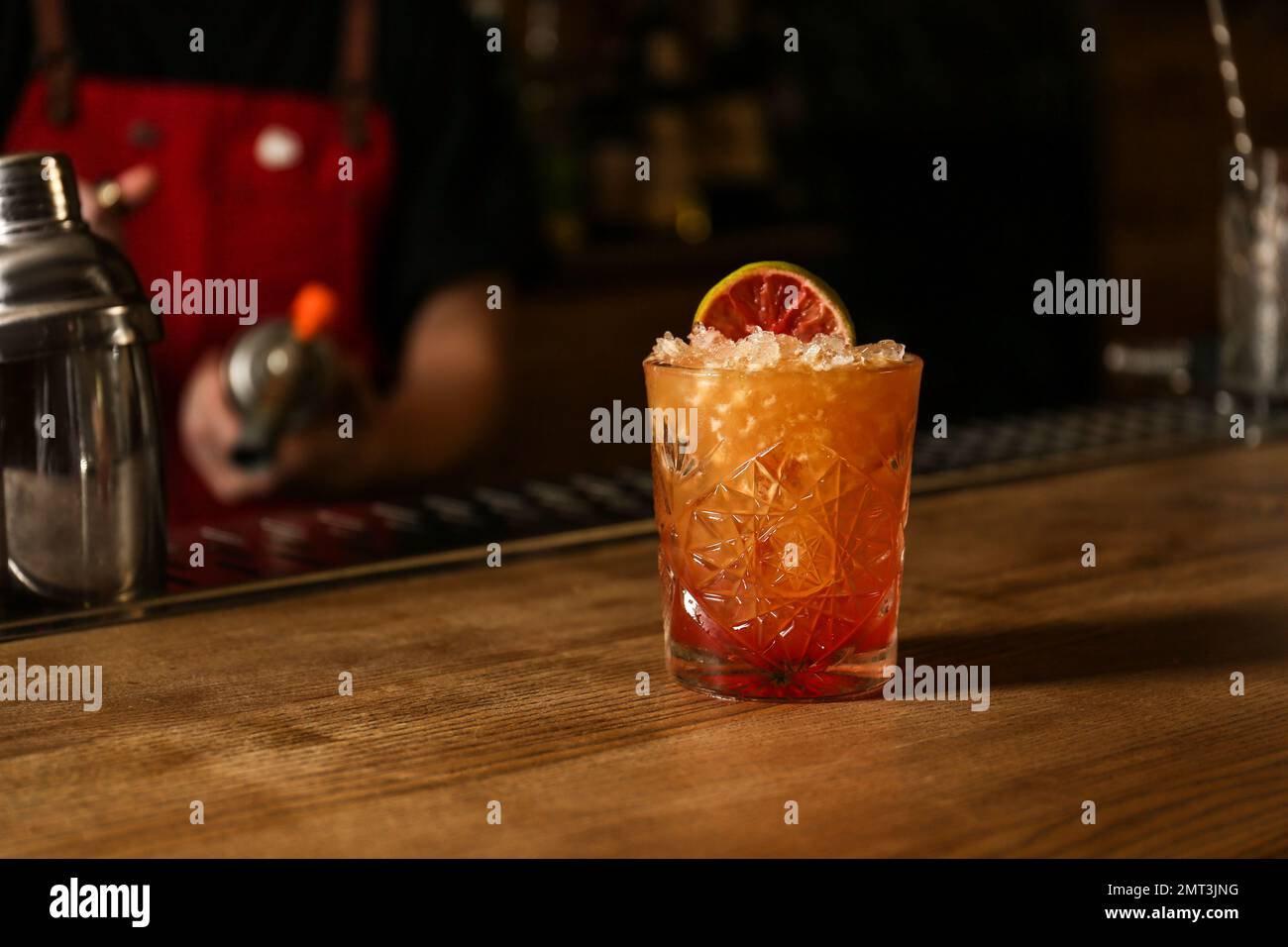 Glass of fresh alcoholic cocktail at bar counter. Space for text Stock Photo
