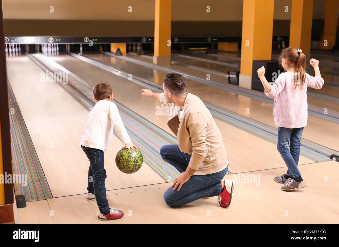 Happy family spending time together in bowling club Stock Photo