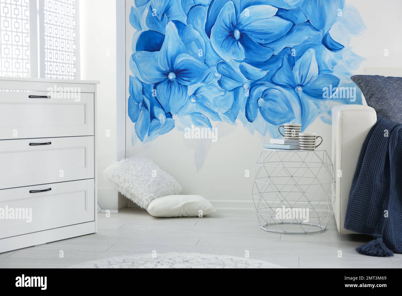 Stylish living room with blue flowers painted on wall. Floral pattern ...