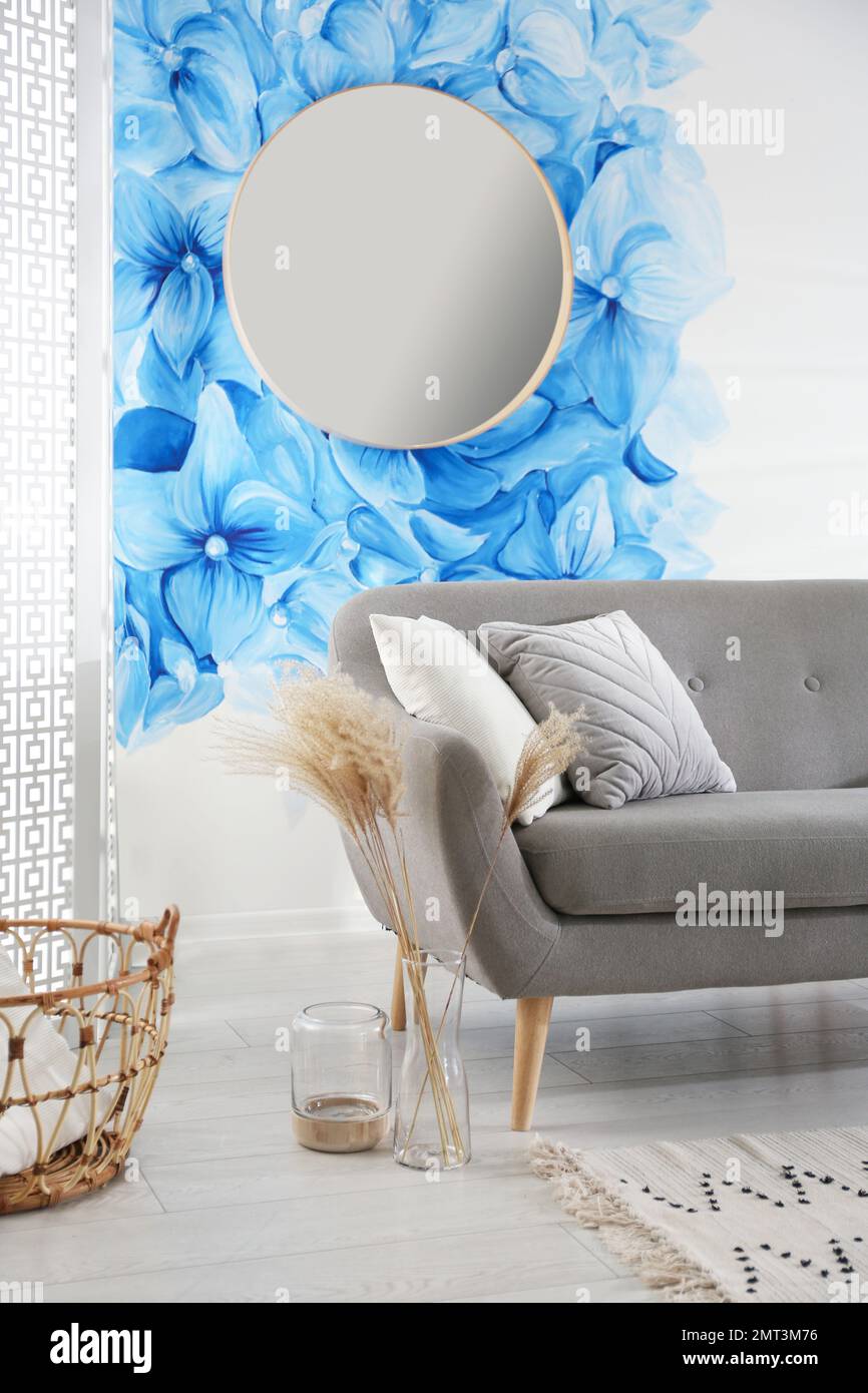 Stylish living room with blue flowers painted on wall. Floral pattern ...