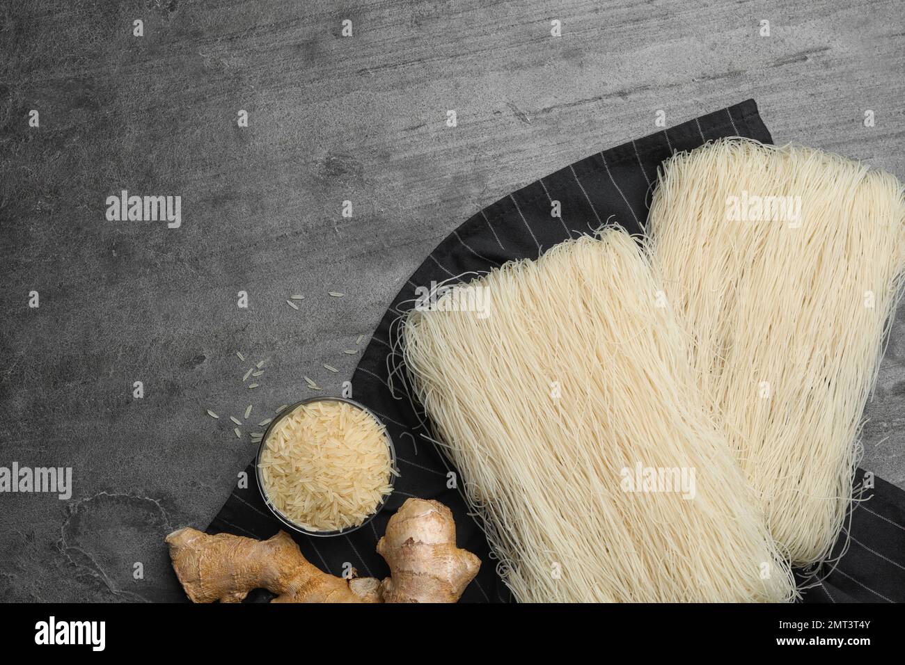 Flat lay composition with rice noodles on grey table, space for text ...