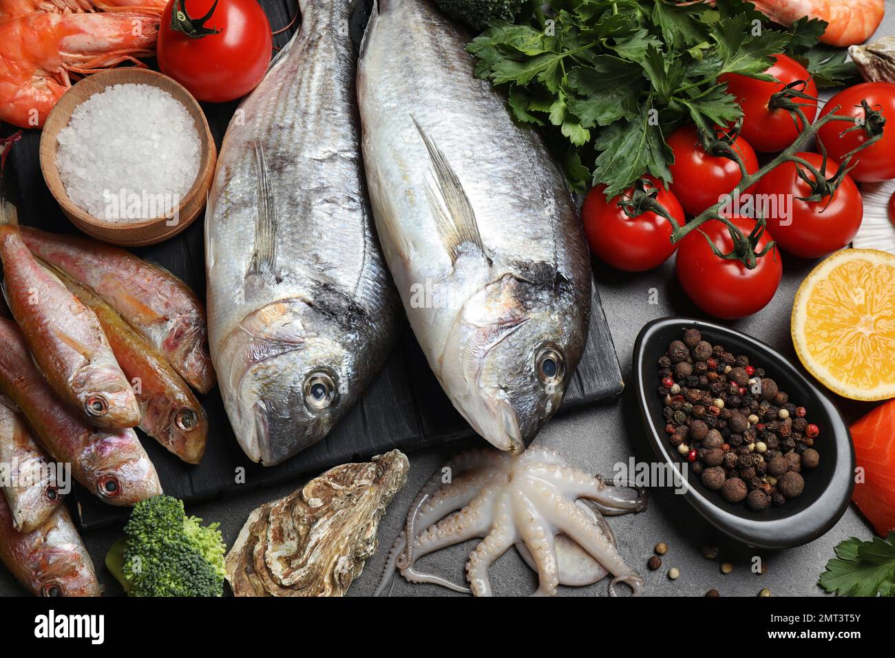 Fresh fish and different seafood on grey table, top view Stock Photo ...