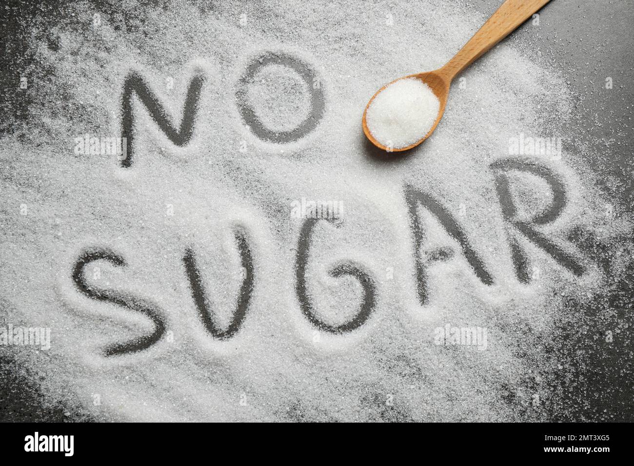 Flat lay composition with phrase NO SUGAR and spoon on grey table Stock Photo