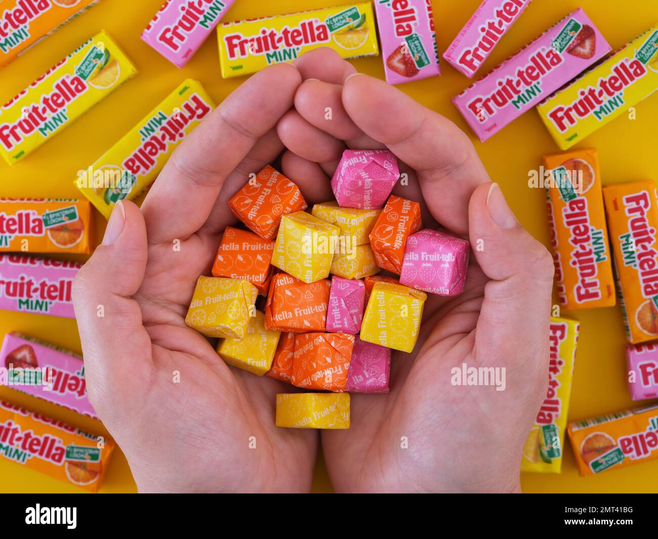 https://c8.alamy.com/comp/2MT41BG/tambov-russian-federation-january-22-2023-a-woman-holding-a-pile-of-different-flovoured-fruit-tella-candies-over-a-background-of-fruitella-mini-pa-2MT41BG.jpg