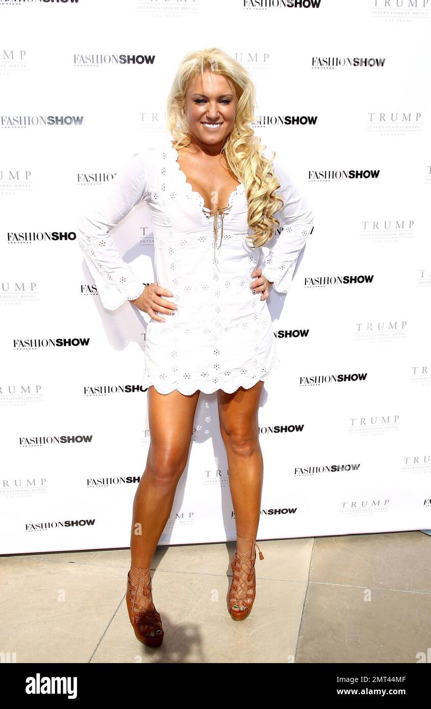Golfer, LPGA tournament winning professional, model and businesswoman Natalie  Gulbis poses for photographers in a white mini dress and lace-up tan high  heels sandals as she host a fashion show at Trump