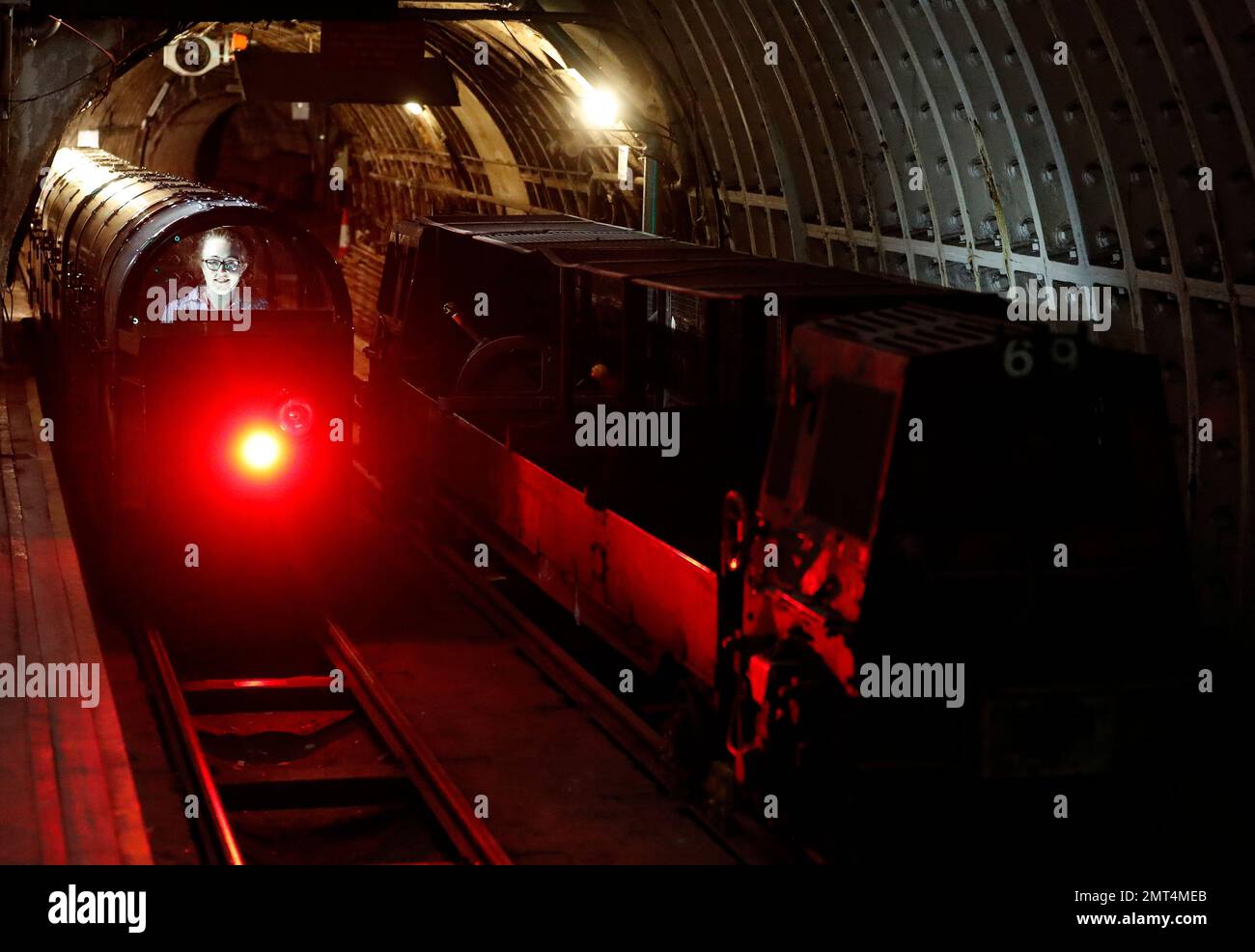 A passenger train rides through the Mail Rail tunnels that is included
