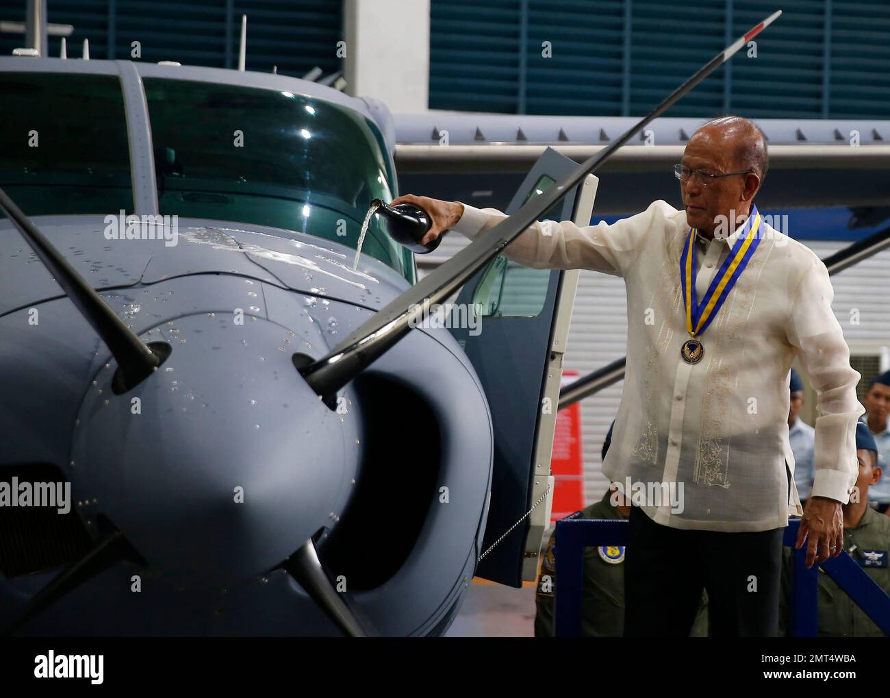 Philippine Defense Chief Delfin Lorenzana pours champagne at the brand