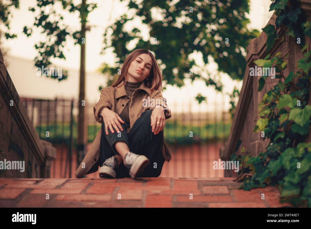 A beautiful Caucasian woman sitting on the ground at the park Stock ...