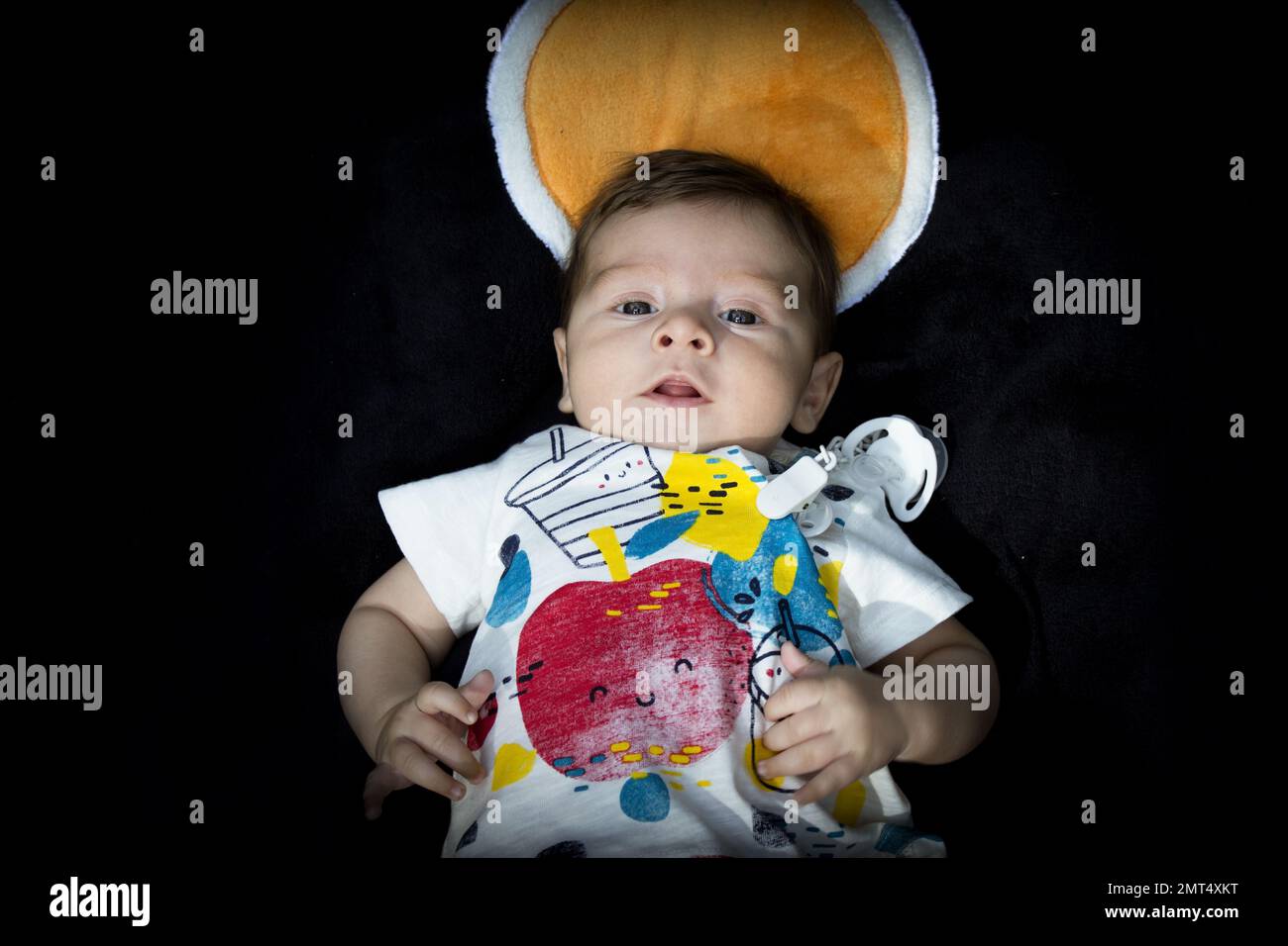 Two month old baby lying on a towel. Happy expression Stock Photo Alamy