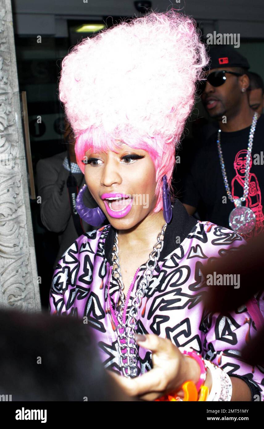Trinidadian-American rapper and R&B singer/songwriter Nicki Minaj is all  smiles as she arrives at BBC Radio 1. Wearing a large pink wig, a wildly  patterned pink jump suit and a large necklace