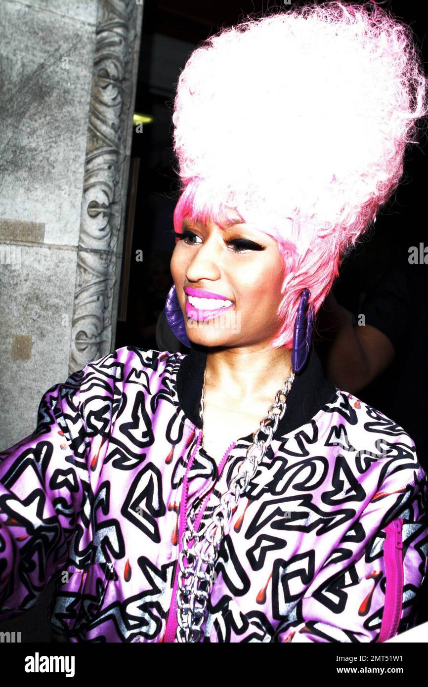 Trinidadian-American rapper and R&B singer/songwriter Nicki Minaj is all  smiles as she arrives at BBC Radio 1. Wearing a large pink wig, a wildly  patterned pink jump suit and a large necklace