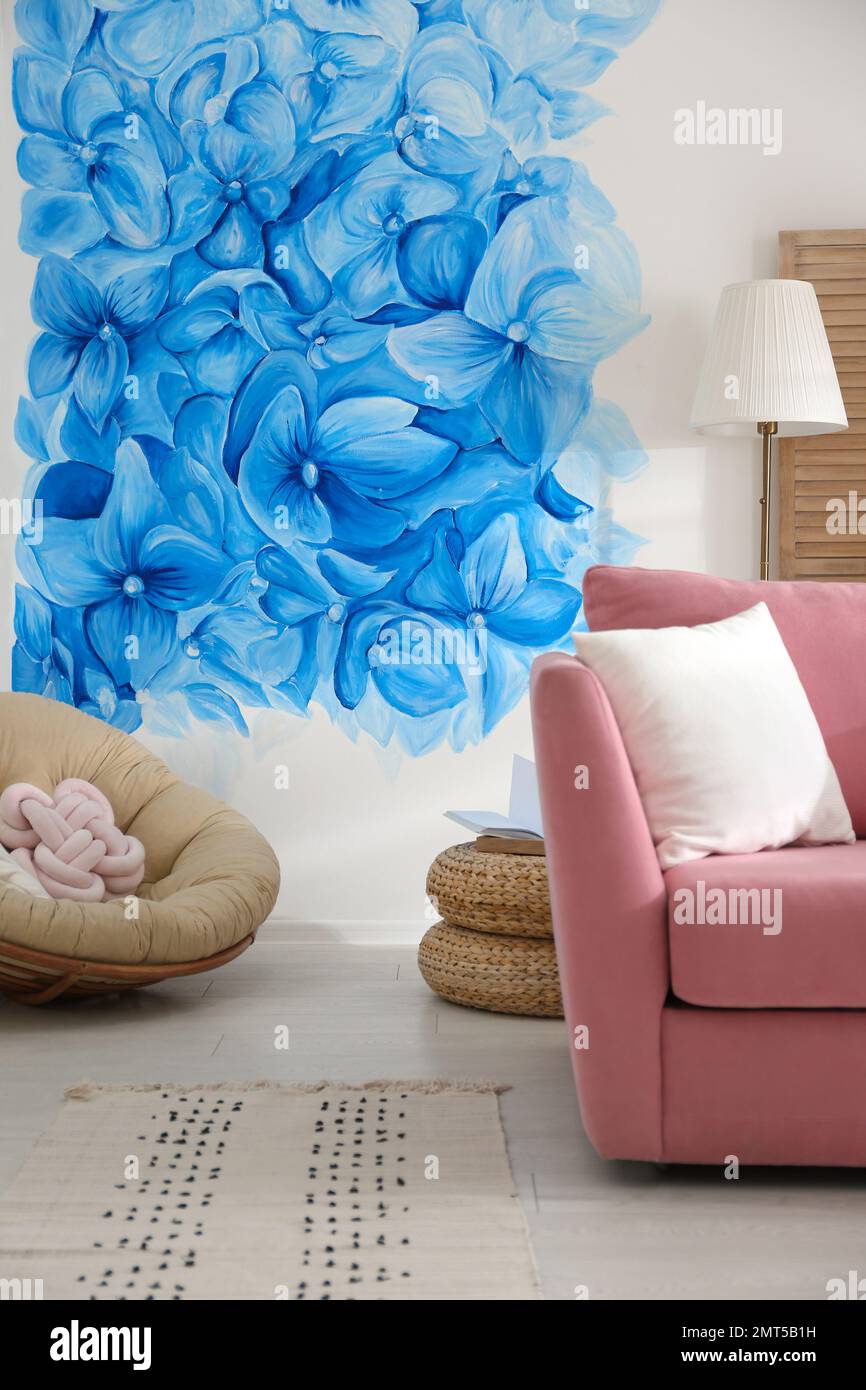 Stylish living room with blue flowers painted on wall. Floral pattern ...