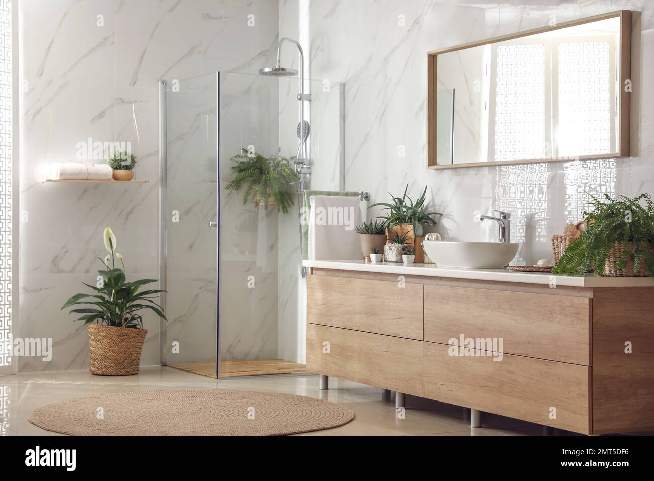 Stylish bathroom interior with countertop, shower stall and houseplants