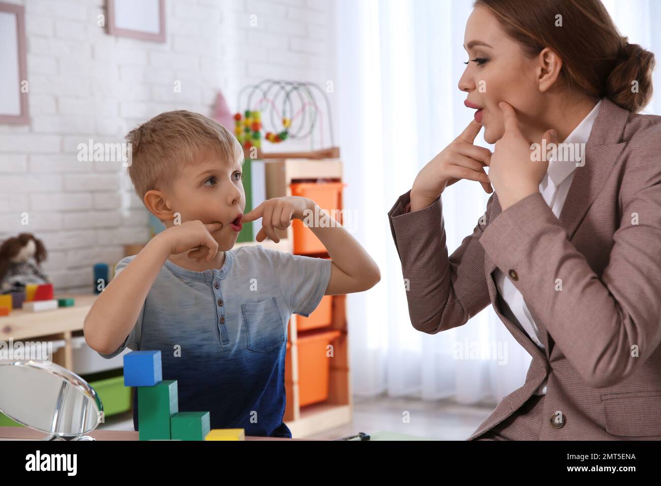 Slp Working Speech therapist working with little boy in office Stock Photo - Alamy