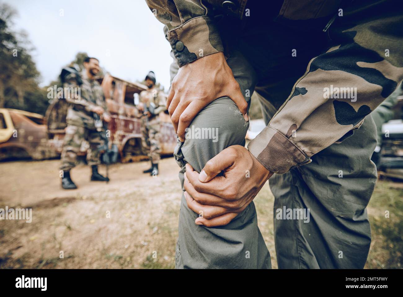 Paintball, injury and leg pain by man on a field for team sports