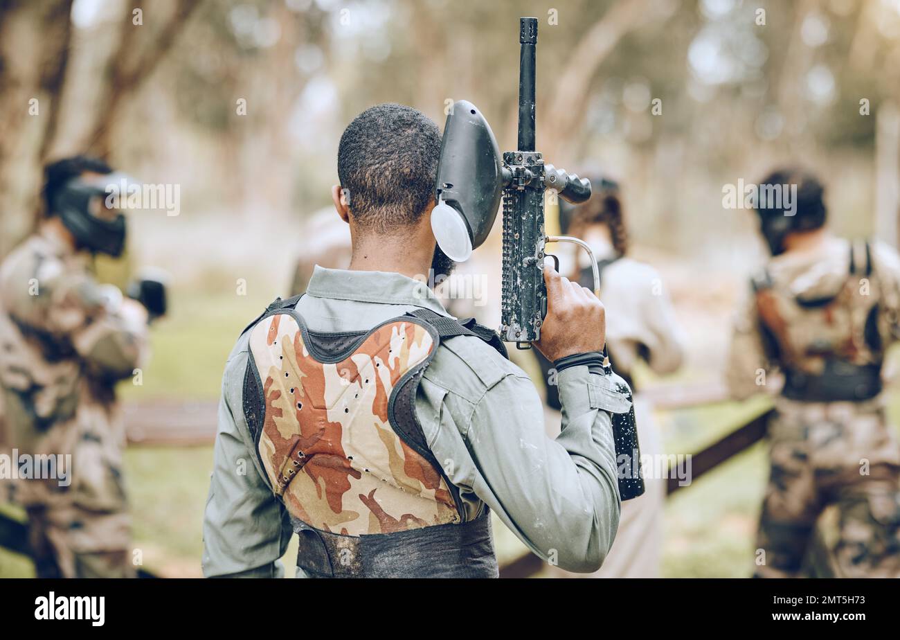 Paintball, gun and back of man in woods ready for games, arena match