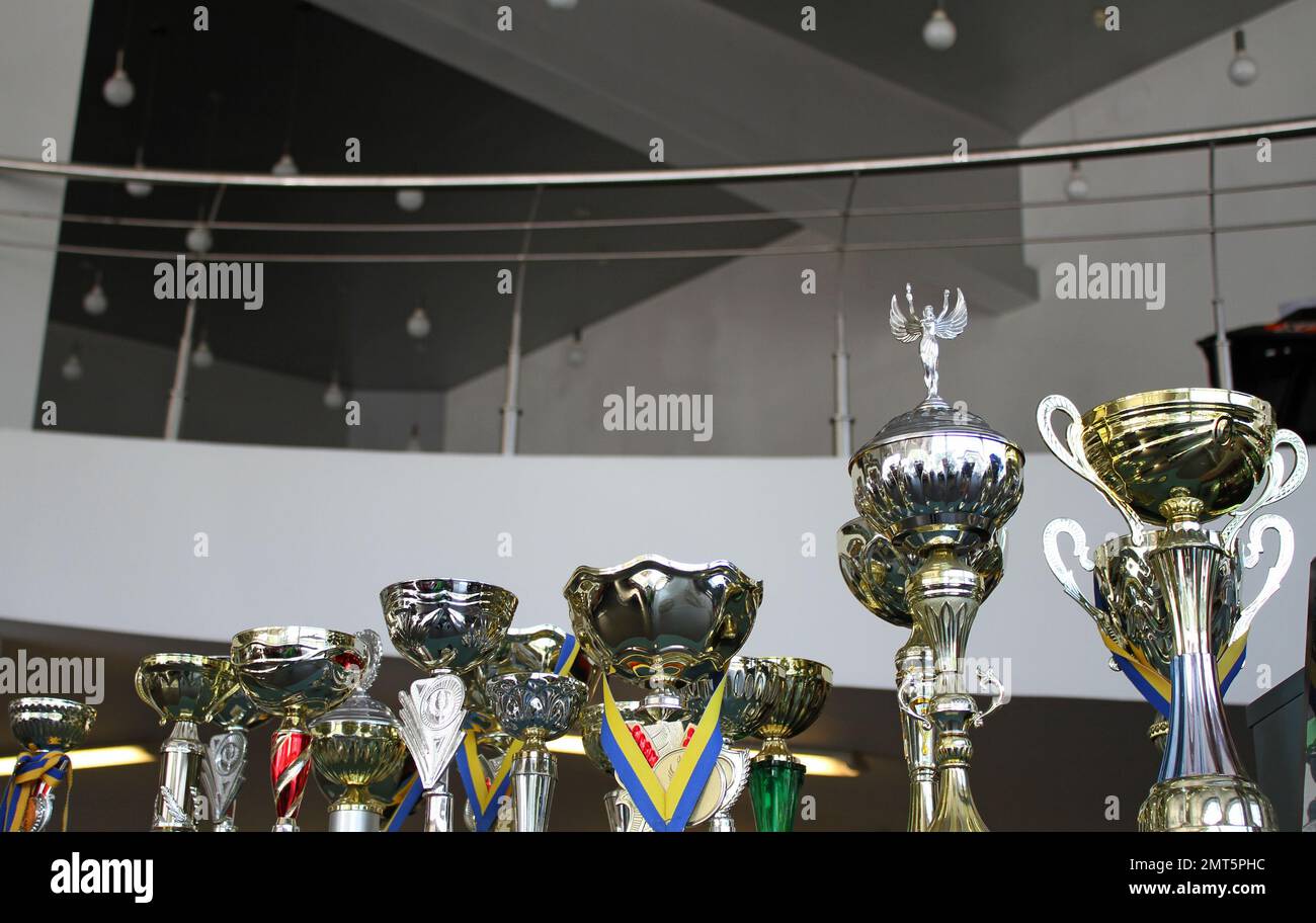 Different cups for winning sports competitions with award strips Stock