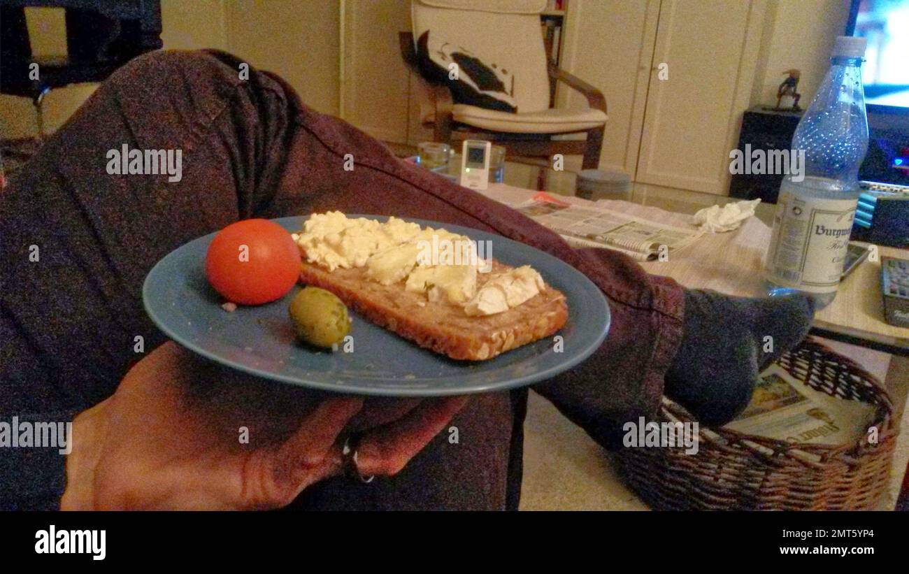 with the plate of sandwiches in front of the television Stock Photo