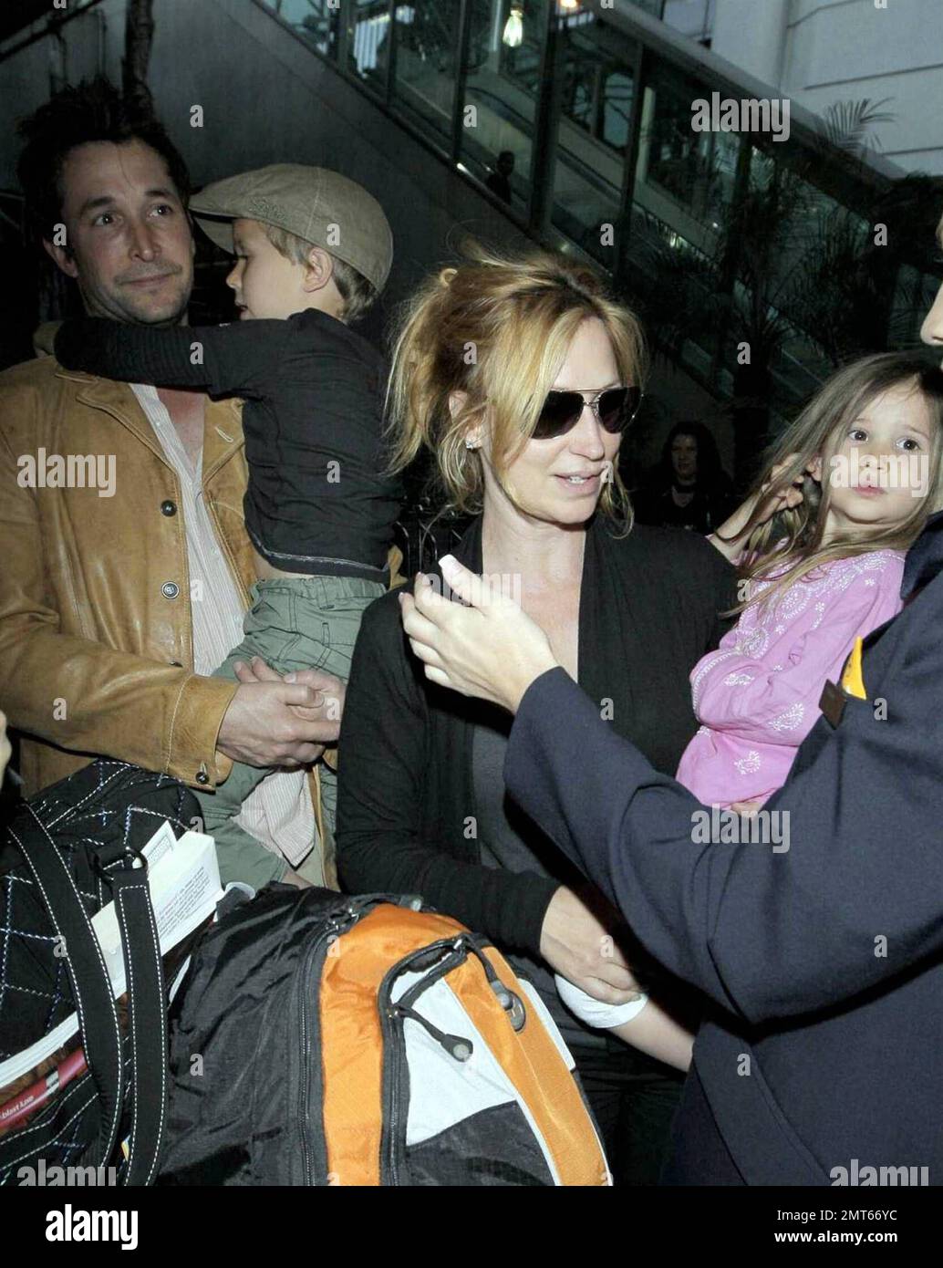 'ER' star Noah Wylie and family arrive stateside at Los Angeles International Airport after a family European vacation. Noah and his wife Tracy Warbin, carried thier children, daughter Auden and son Owen Strausser through the airport as they were assisted with their luggage. The kids looked tired after the long flight. Los Angeles, CA. 4/29/09.   . Stock Photo