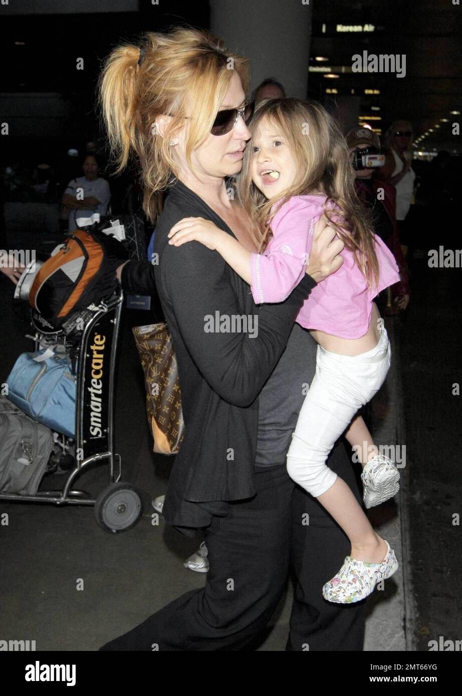 'ER' star Noah Wylie and family arrive stateside at Los Angeles International Airport after a family European vacation. Noah and his wife Tracy Warbin, carried thier children, daughter Auden and son Owen Strausser through the airport as they were assisted with their luggage. The kids looked tired after the long flight. Los Angeles, CA. 4/29/09.   . Stock Photo