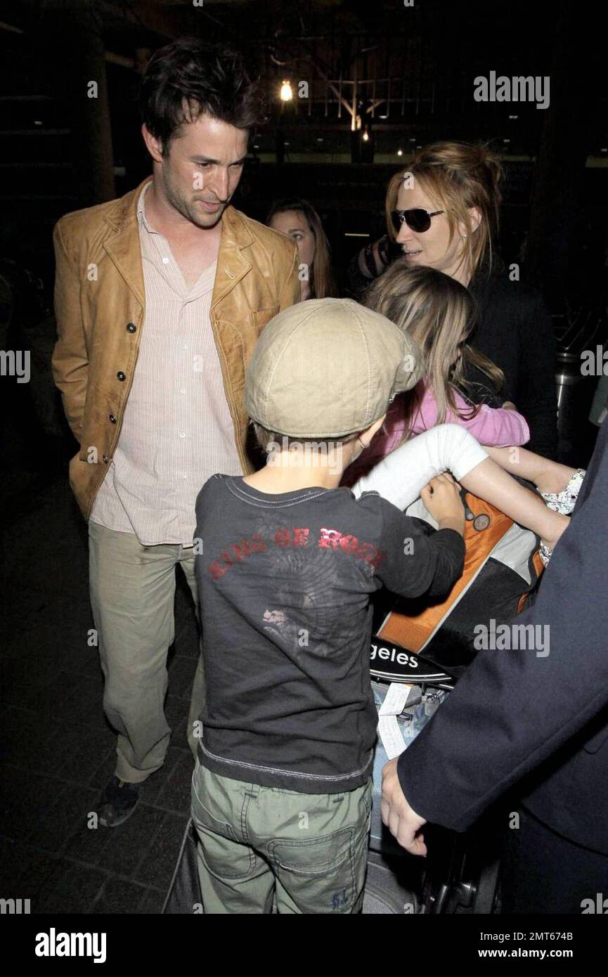 'ER' star Noah Wylie and family arrive stateside at Los Angeles International Airport after a family European vacation. Noah and his wife Tracy Warbin, carried thier children, daughter Auden and son Owen Strausser through the airport as they were assisted with their luggage. The kids looked tired after the long flight. Los Angeles, CA. 4/29/09. Stock Photo