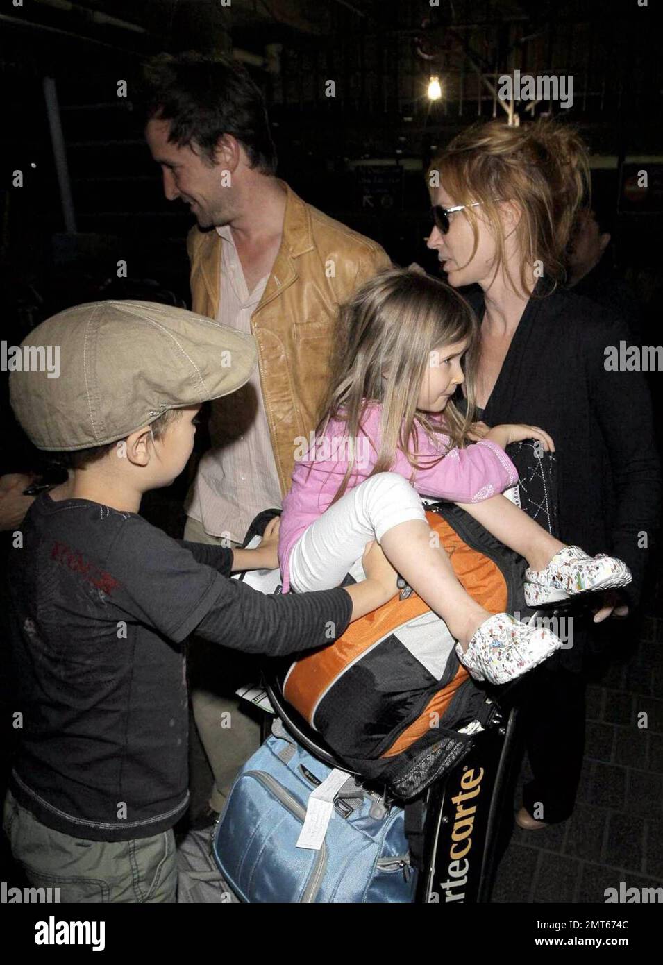 'ER' star Noah Wylie and family arrive stateside at Los Angeles International Airport after a family European vacation. Noah and his wife Tracy Warbin, carried thier children, daughter Auden and son Owen Strausser through the airport as they were assisted with their luggage. The kids looked tired after the long flight. Los Angeles, CA. 4/29/09. Stock Photo