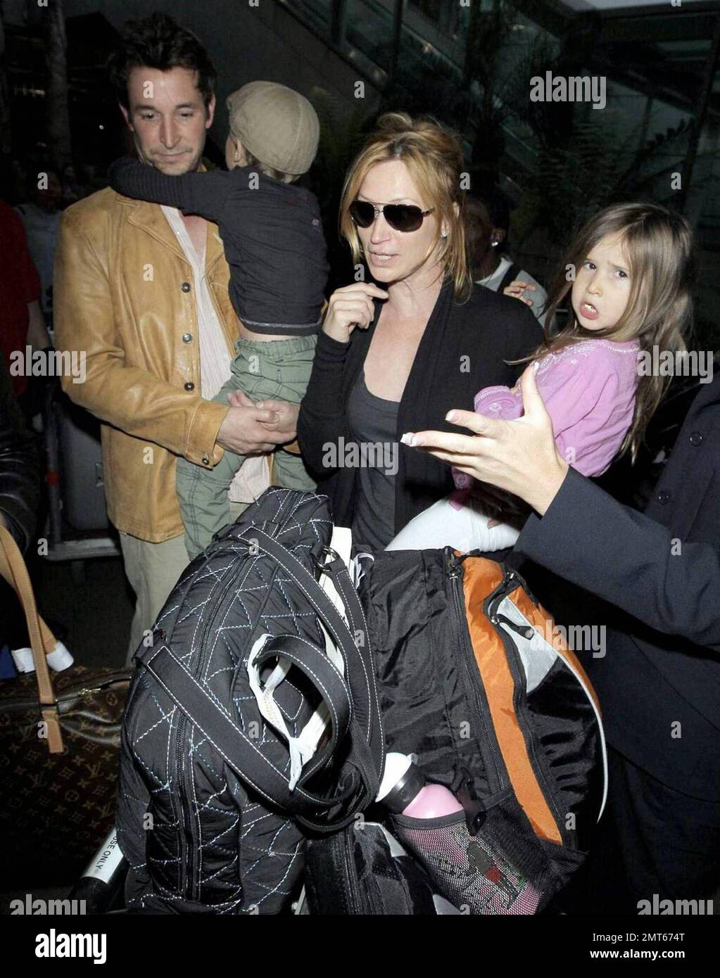 'ER' star Noah Wylie and family arrive stateside at Los Angeles International Airport after a family European vacation. Noah and his wife Tracy Warbin, carried thier children, daughter Auden and son Owen Strausser through the airport as they were assisted with their luggage. The kids looked tired after the long flight. Los Angeles, CA. 4/29/09. Stock Photo