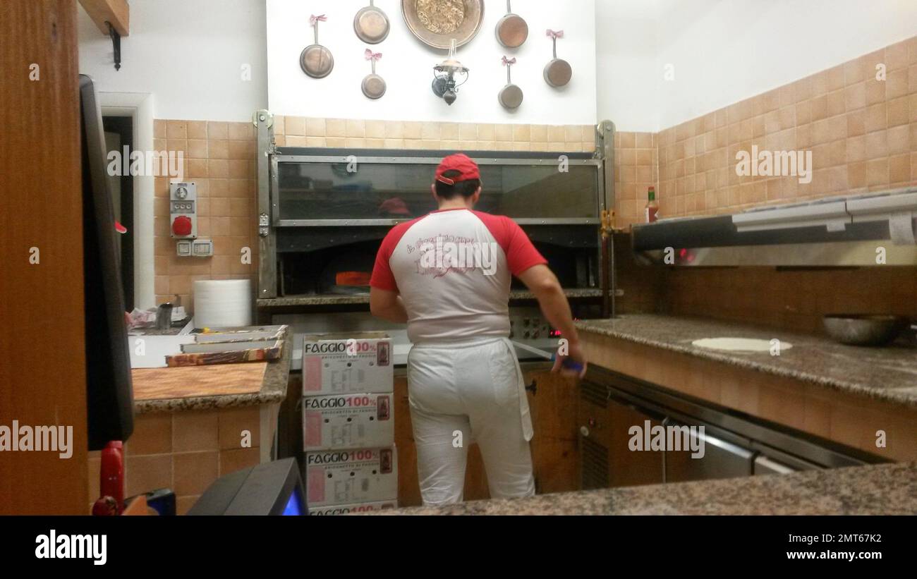 Pizza maker in a pizzeria in front of the oven Stock Photo