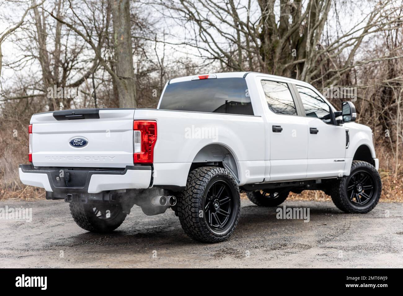 A rear view of a white 2020 Ford F-250 pickup truck with lifted wheels