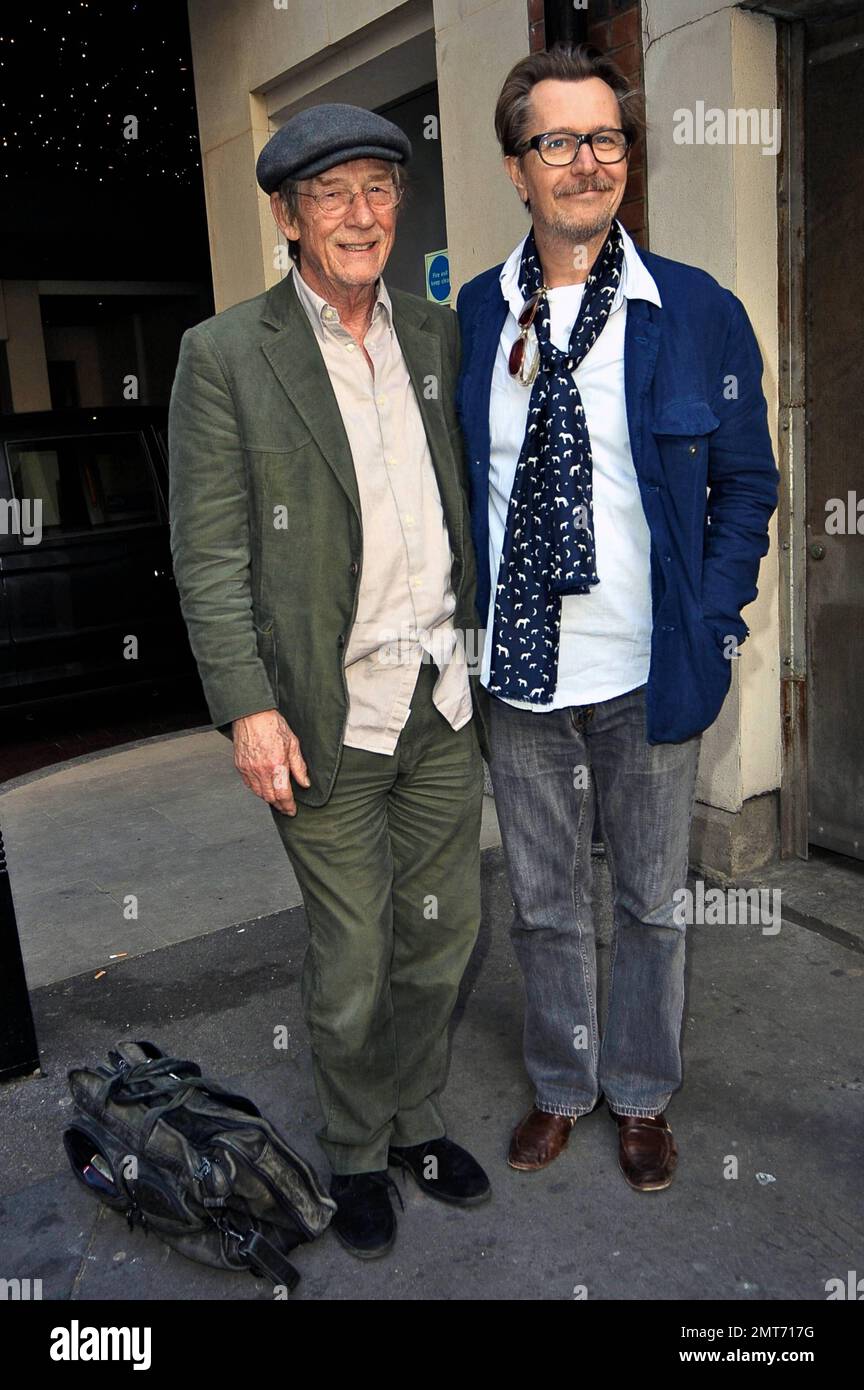 English actors Gary Oldman and John Hurt pose for photos while chatting