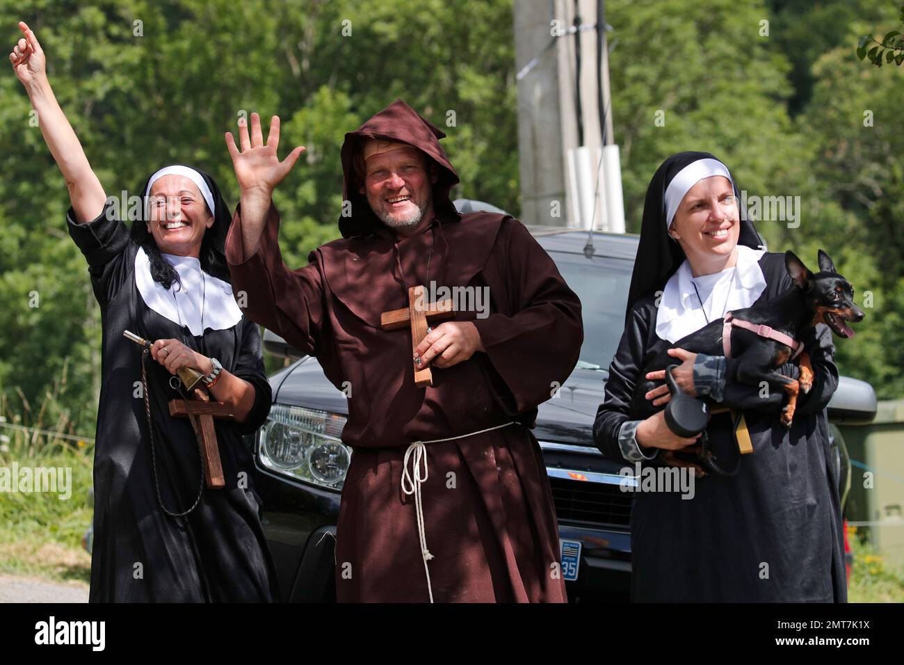 Spectators wearing costumes wait of the riders to pass during the