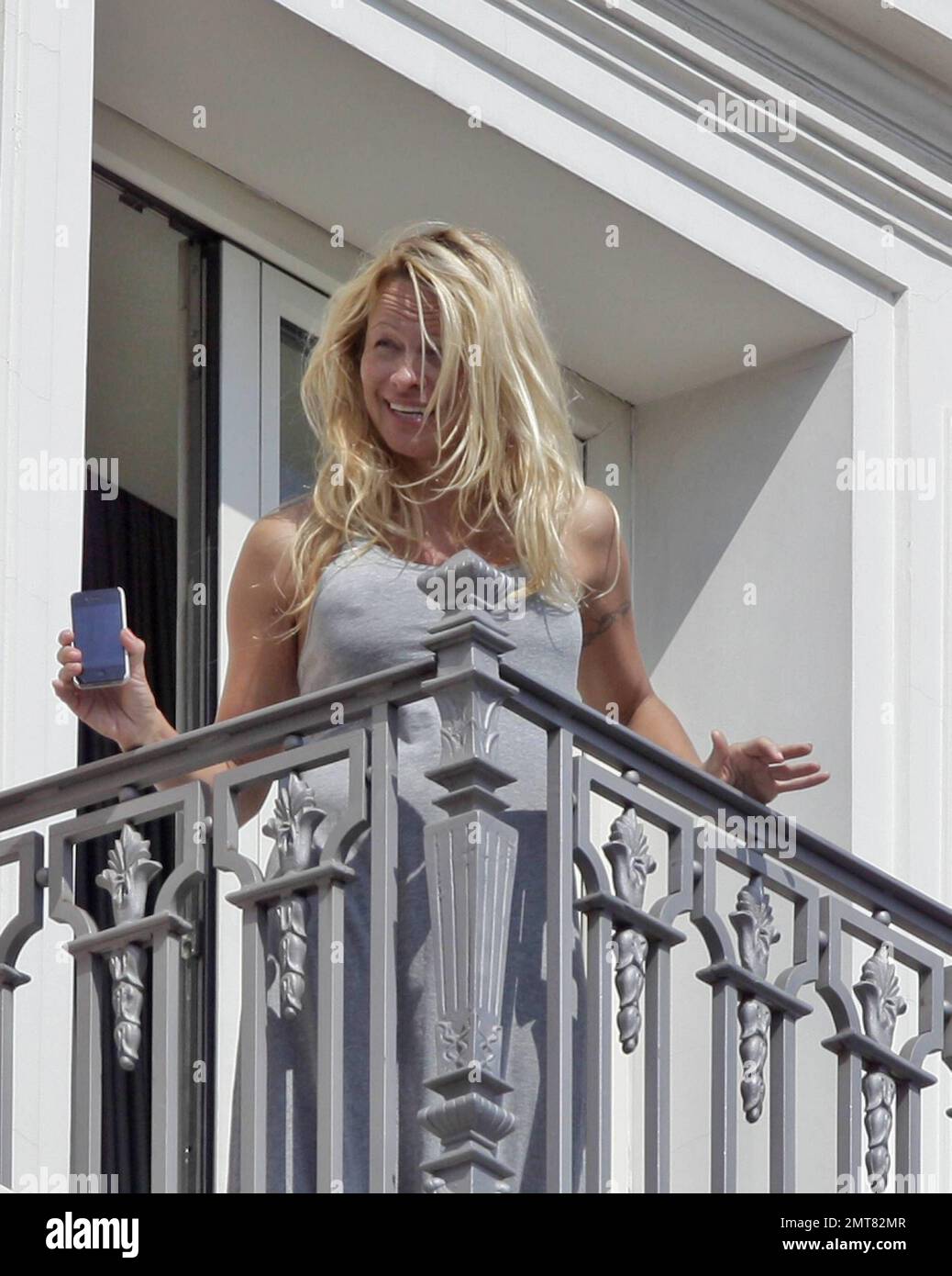 GREECE OUT - EXCLUSIVE!! Anderson takes to the balcony of her luxury hotel as though she's just out of bed. Wearing her night gown and no makeup, Pam