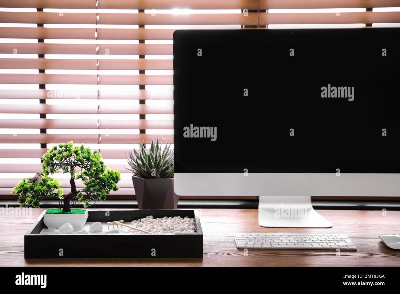 Modern workplace with beautiful miniature zen garden and computer in ...