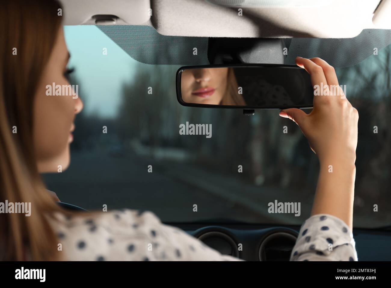 Young woman adjusting rear view mirror in car, closeup Stock Photo Alamy