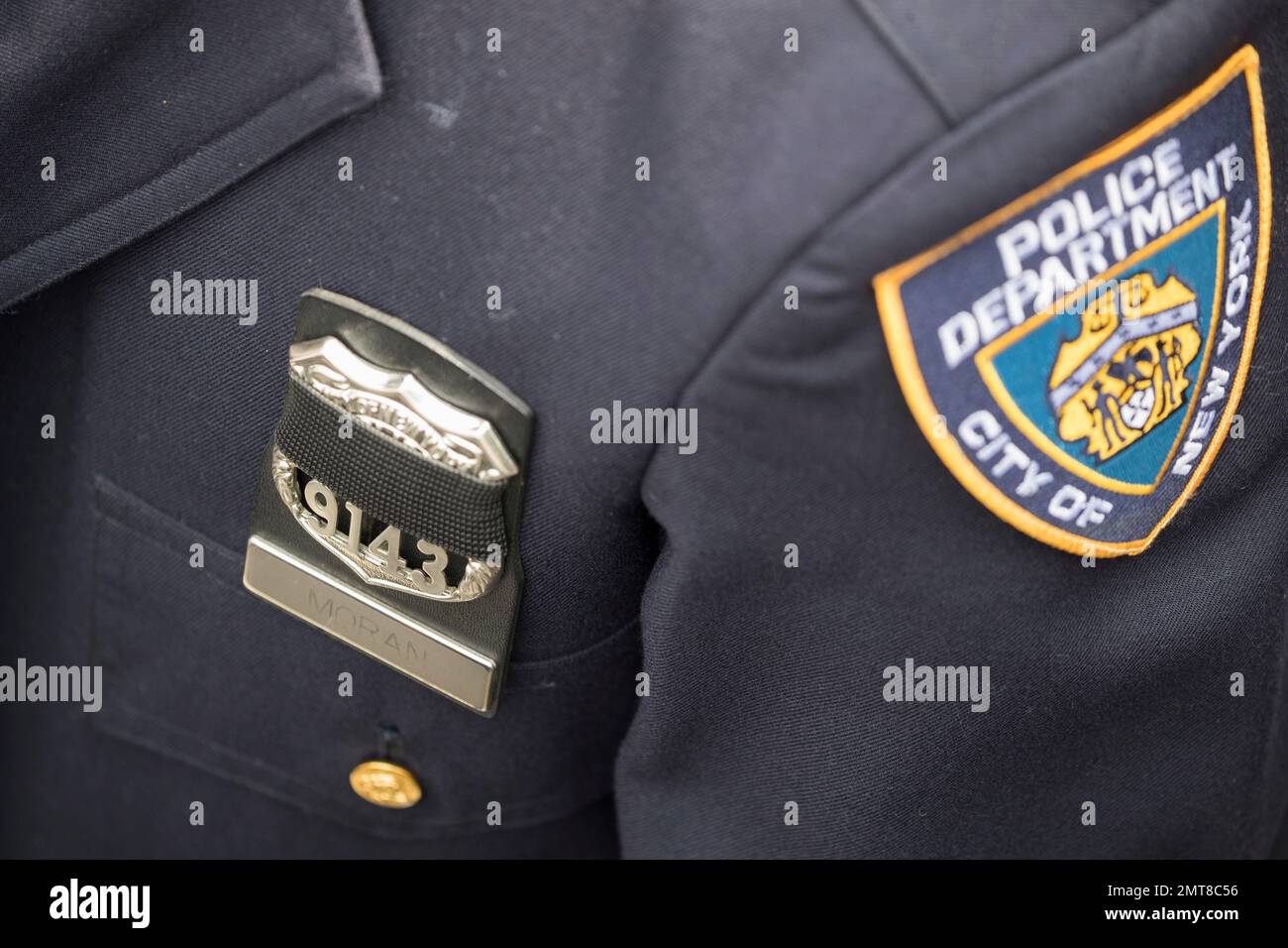 A police officer wears a mourning band over her badge during the ...