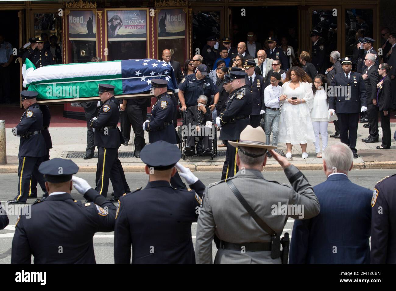 Police officers salute as slain New York City Police officer Miosotis Familia's mother Adriana