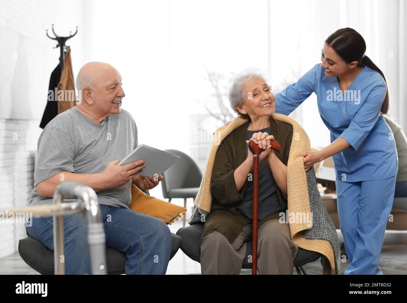 Nurse taking care of elderly patients in geriatric hospice Stock Photo
