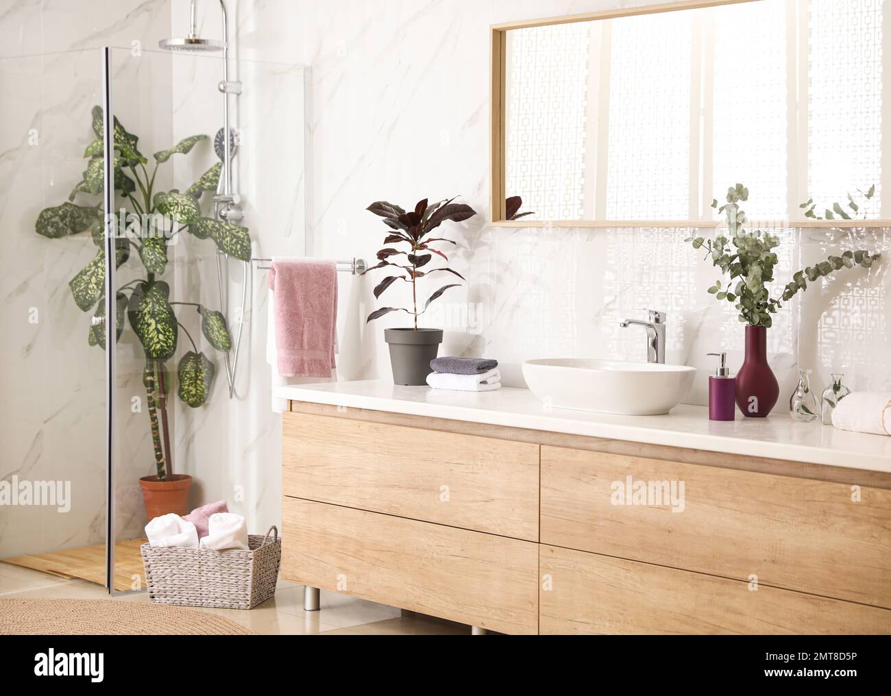 Stylish bathroom interior with countertop, shower stall and houseplants