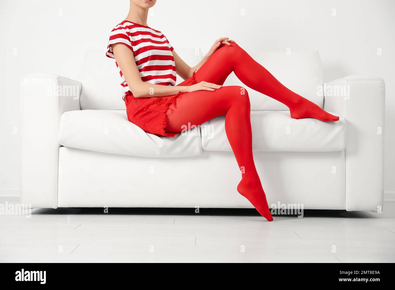 Woman wearing red tights sitting on sofa indoors, closeup Stock Photo -  Alamy