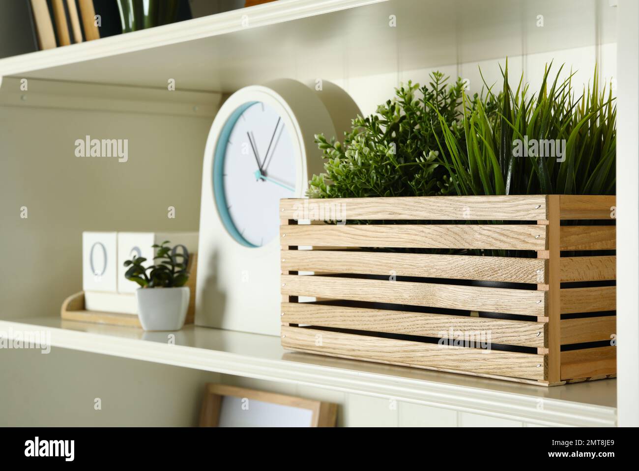 White shelving unit with plants, clock and calendar Stock Photo Alamy