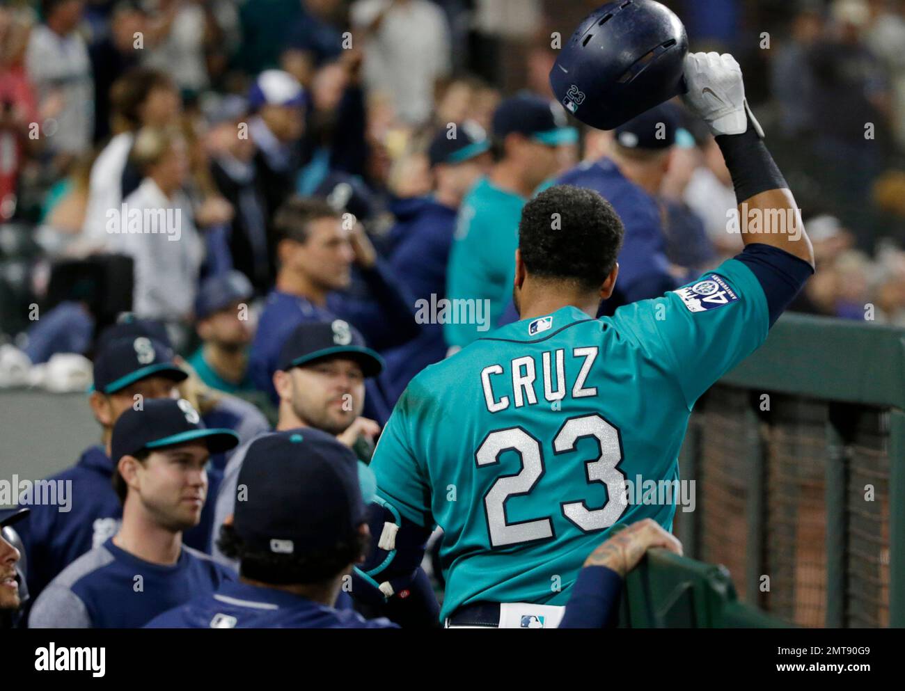 Seattle Mariners' Nelson Cruz tips his batting helmet to the crowd from the  dugout after he hit a three-run home run during the eighth inning of the  team's baseball game against the