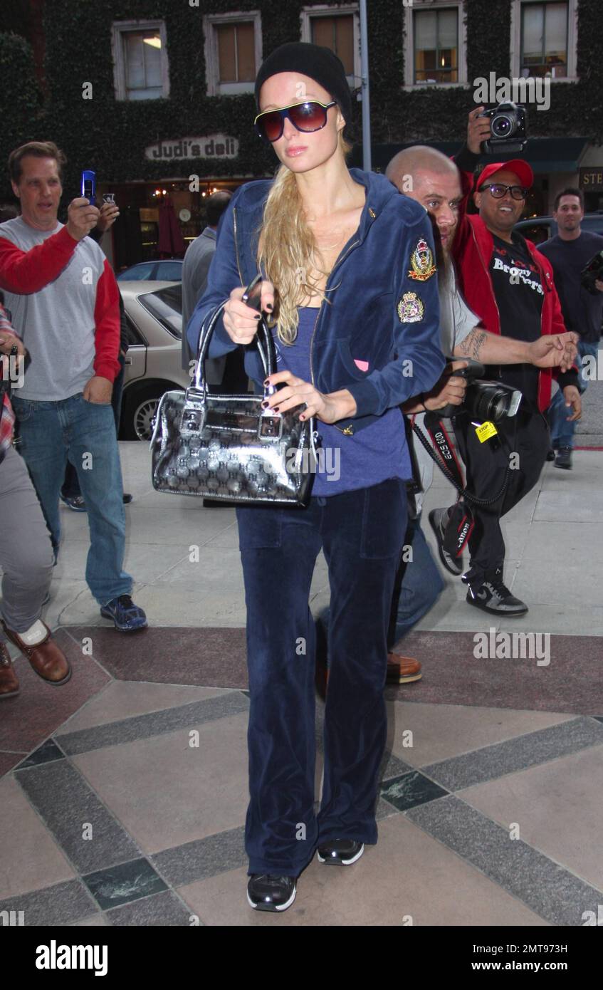 Paris Hilton looks forlorn as she leaves an appointment wearing a black  cap, sunglasses and a blue track suit. Paris looked to be in a hurry as she  headed to her waiting