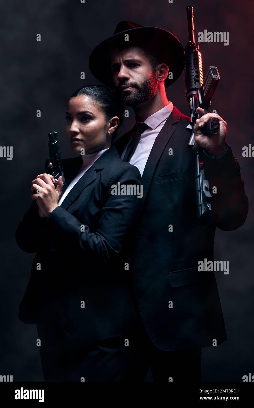 Gangster couple, fashion or gun on studio background in secret spy,  isolated mafia safety or crime lord security. Man, love or model woman with  pistol Stock Photo - Alamy